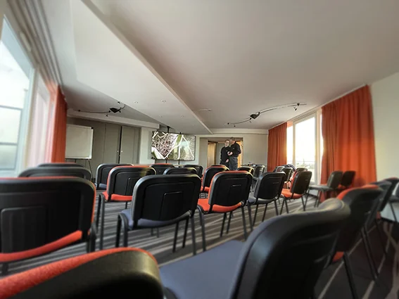 Grand écran et sièges dans une salle professionnelle du Lodge.